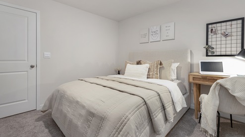 Secondary carpeted bedroom with small window