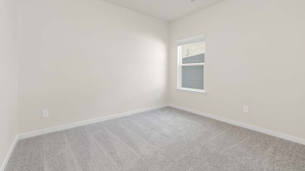 Carpeted bedroom with small window, being used as an office
