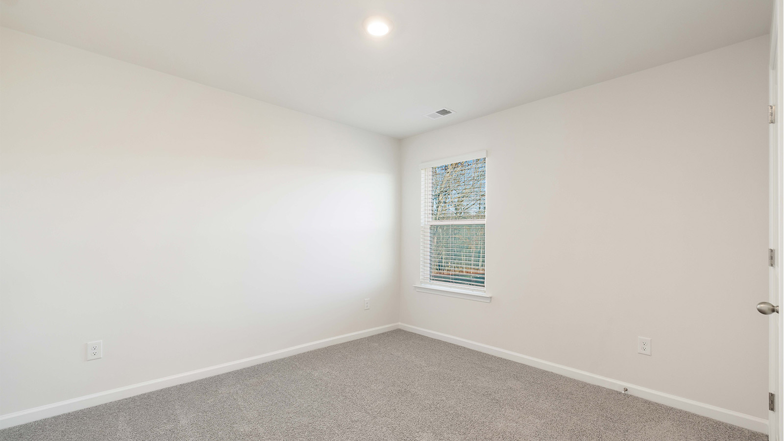 Carpeted bedroom with large windows