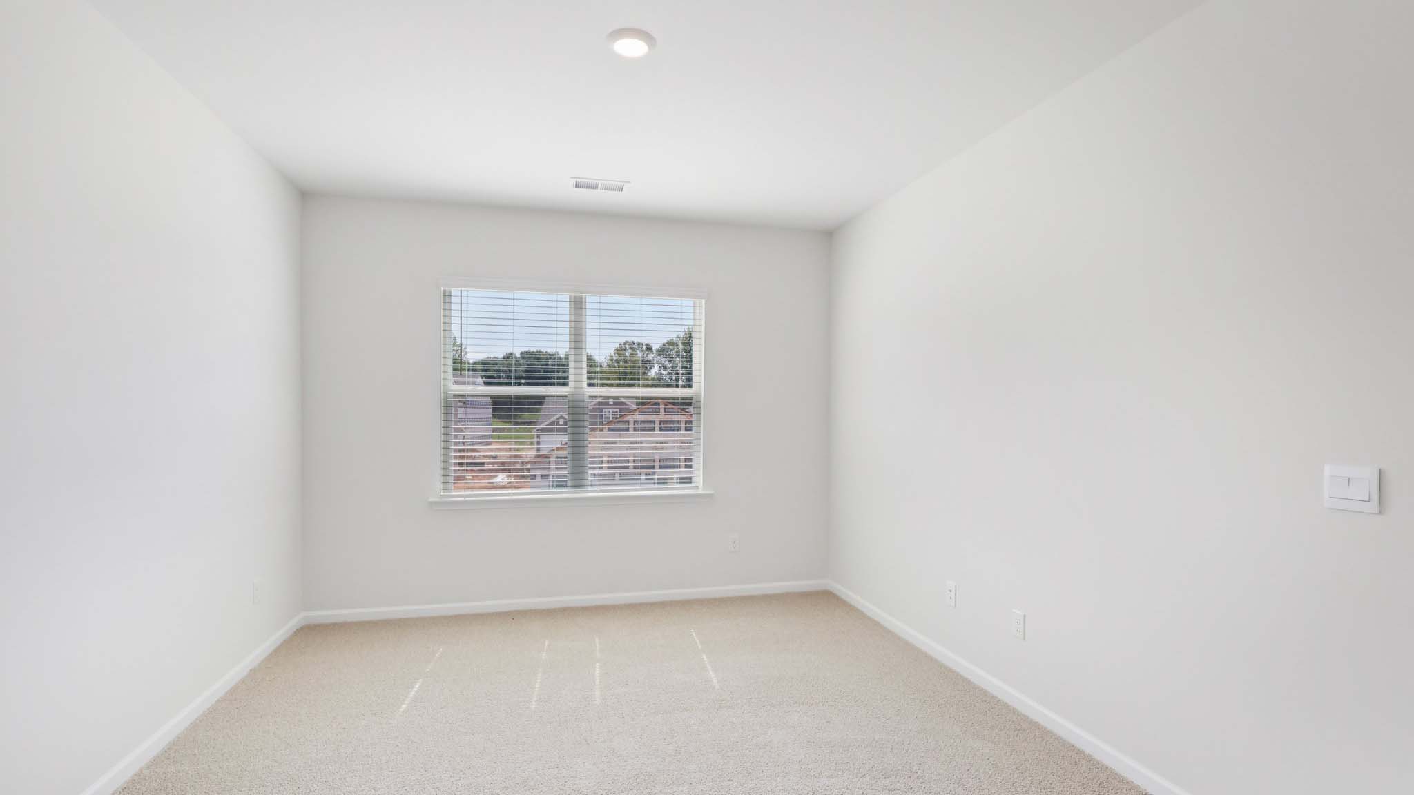 Carpeted bedroom with large window