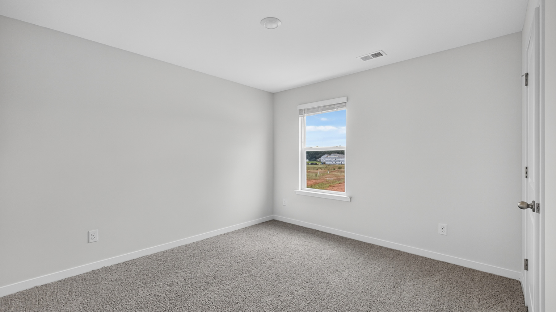 carpeted bedroom with large window
