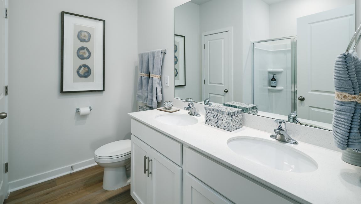 Primary bathroom with double sinks and standing glass shower