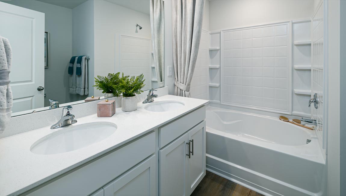 Primary bathroom with double sinks and standing glass shower