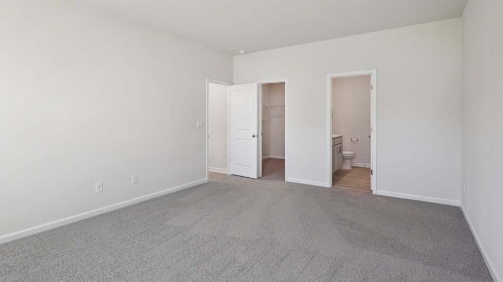 Primary bedroom with carpet and two large windows