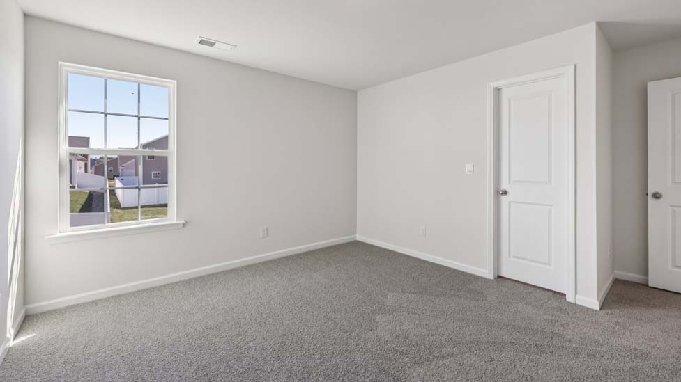 carpeted bedroom with large window