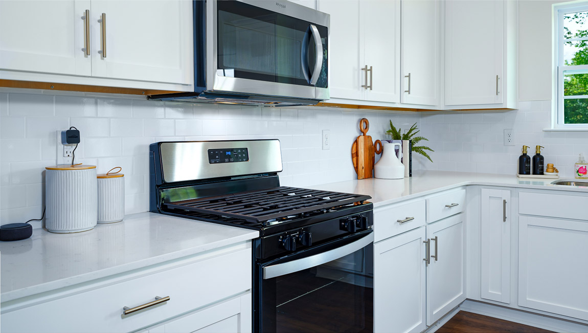 Kitchen and island with white counters and cabinets