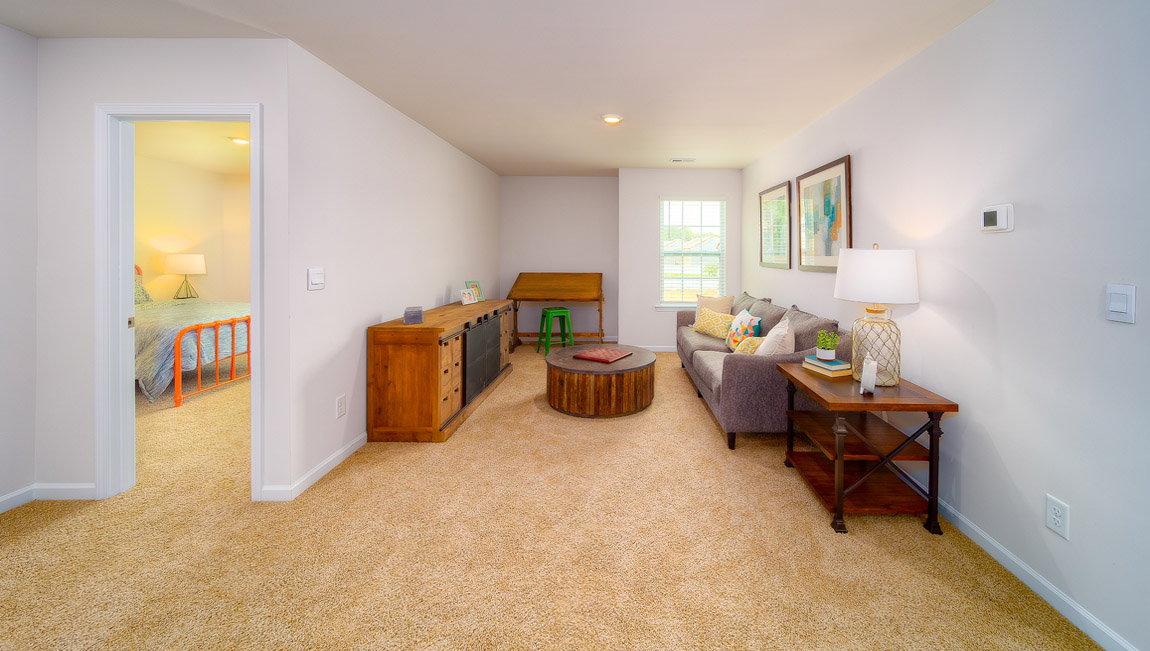 Open upstairs carpeted loft space with small window