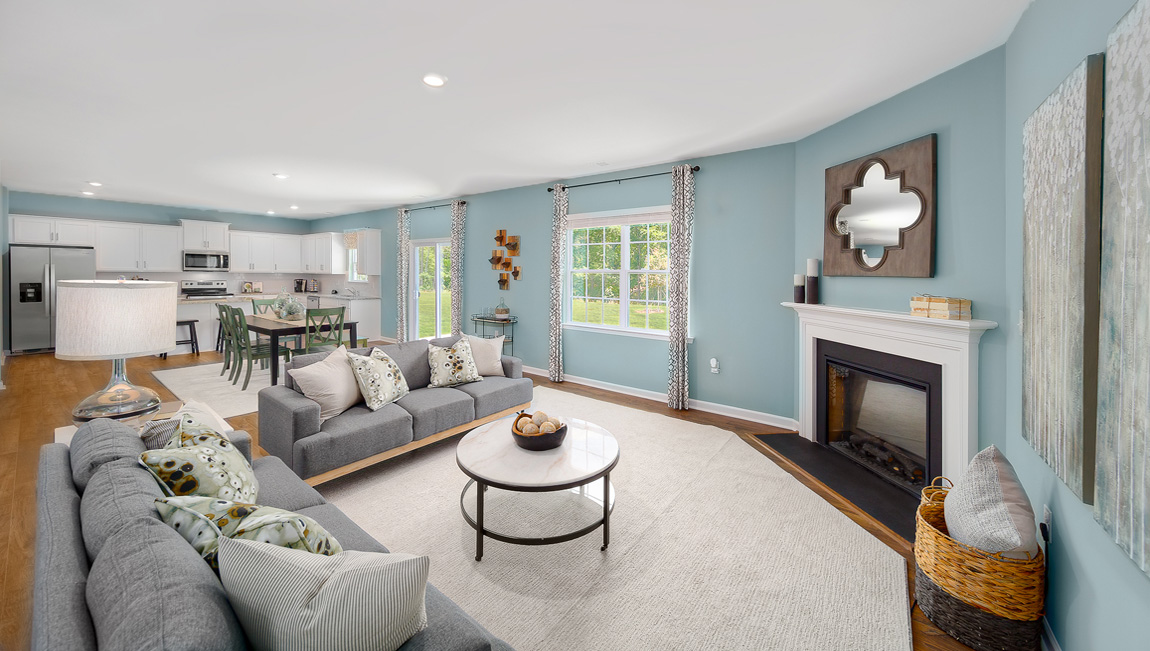 Open family room with fireplace, windows, and view of dining and kitchen