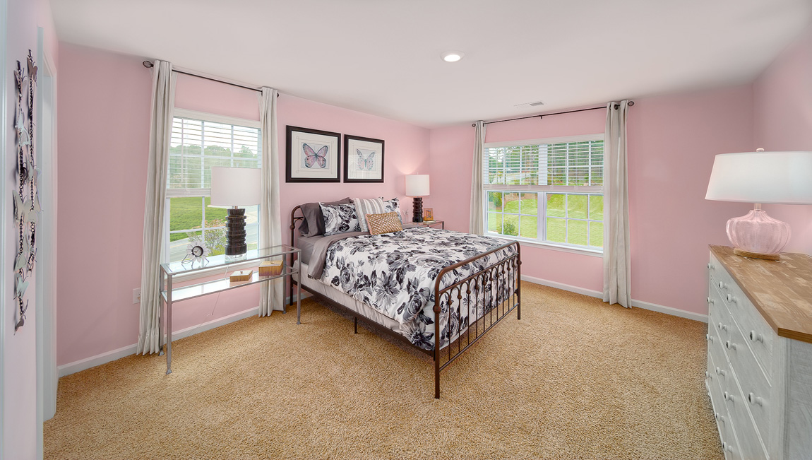 Carpeted bedroom with two large windows