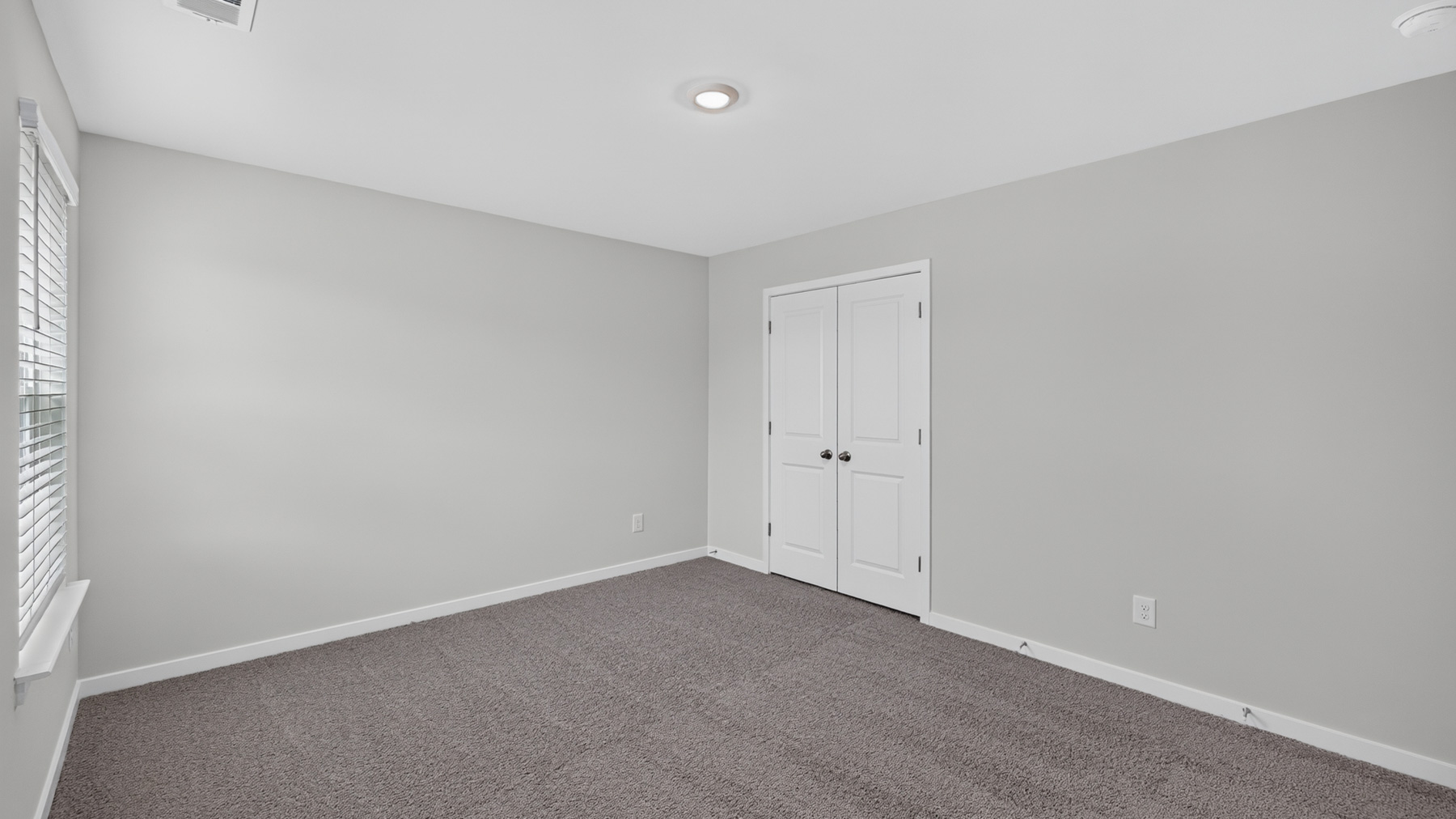 Carpeted bedroom with large window