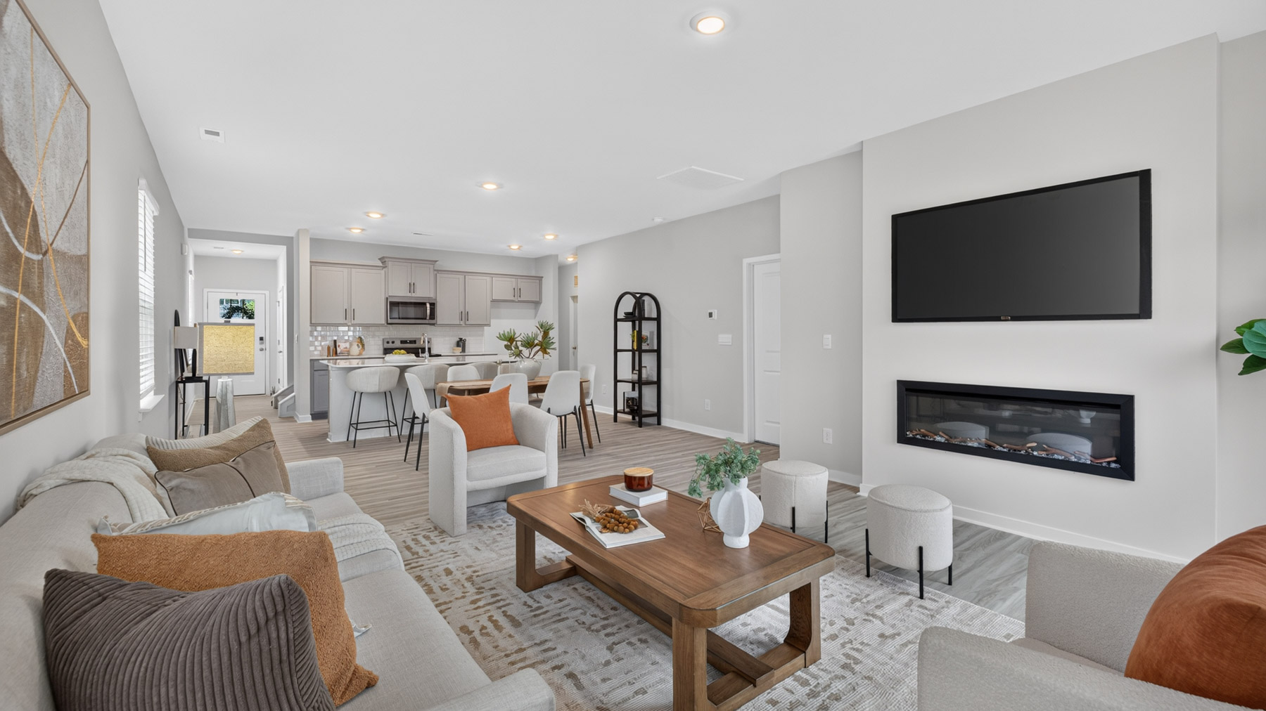 Open living room with fire place, vinyl floors, and large window