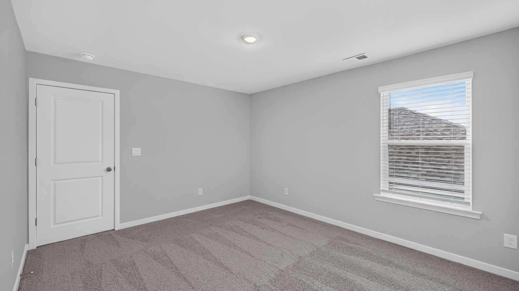 Carpeted bedroom with large window