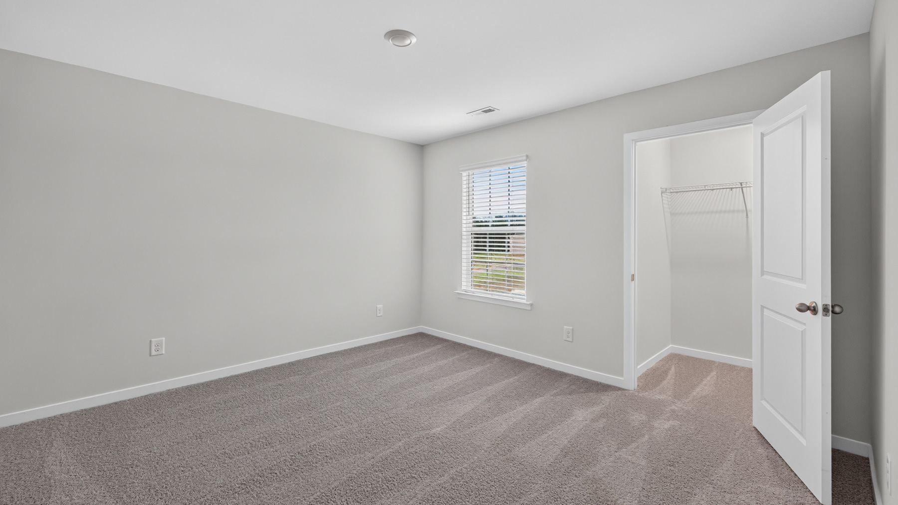Carpeted bedroom with large window
