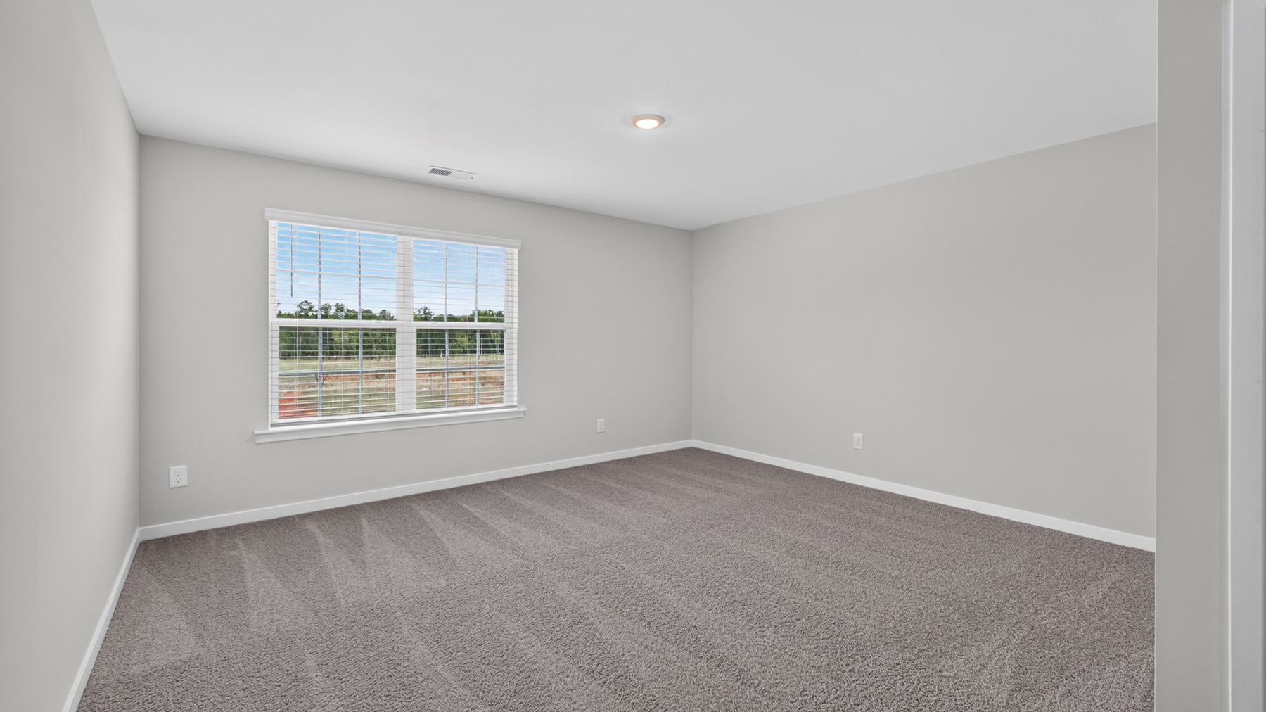 Carpeted bedroom with large window