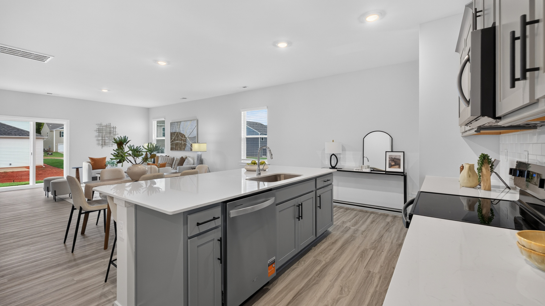 Kitchen with island, white cabinets, vinyl floors, and stainless steel appliances