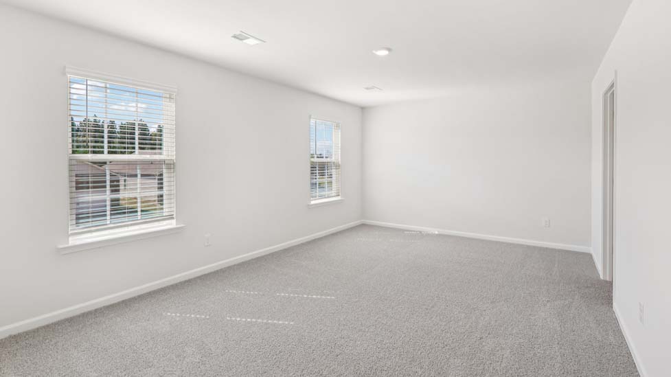 Carpeted bedroom with windows