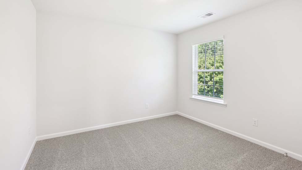 Carpeted bedroom with windows