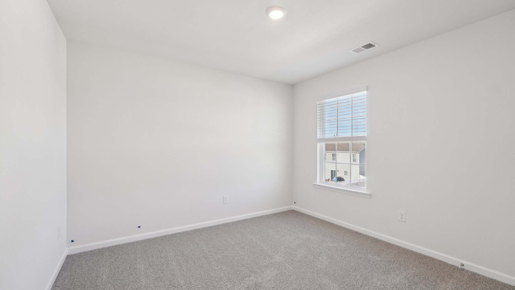 Carpeted bedroom with windows
