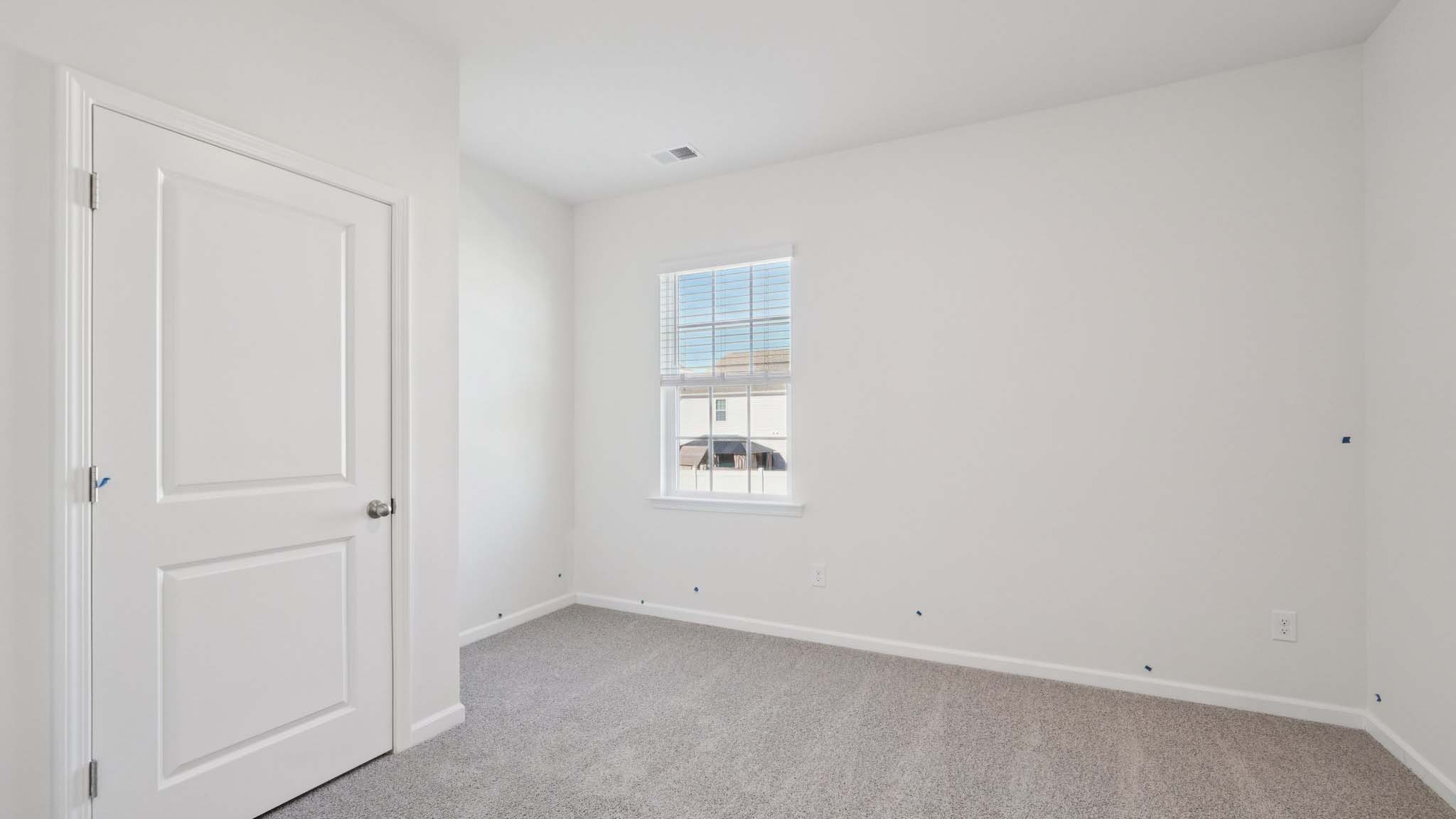 Carpeted bedroom with windows