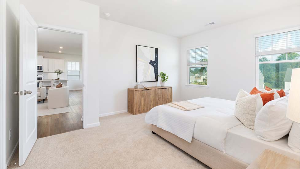 Primary bedroom with carpet and two large windows