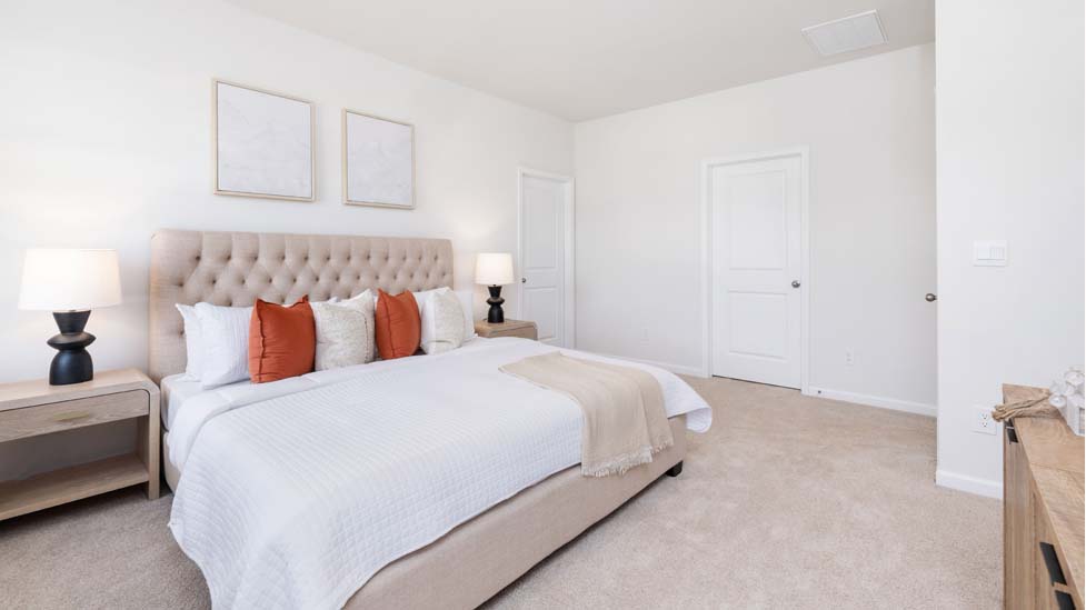 Primary bedroom with carpet and two large windows