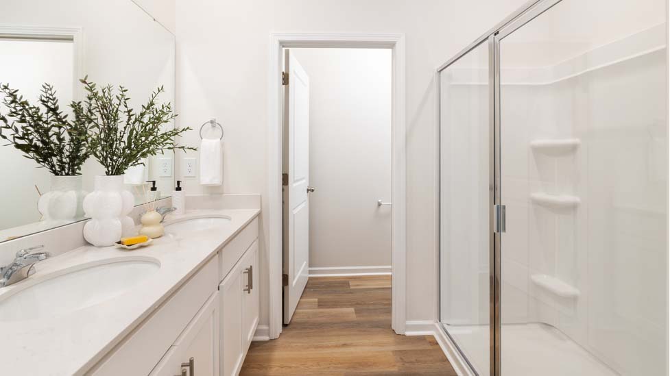 Primary bathroom with double sinks and glass shower