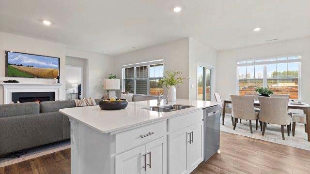 Kitchen and island with quartz countertops, white cabinets, and stainless steel appliances