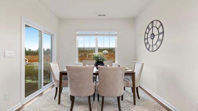 Dining room with large window, and sliding glass back door