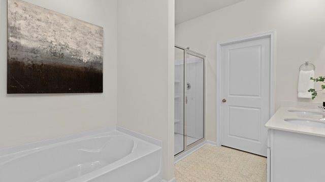 Bathroom with white counters and cabinets, and glass door shower