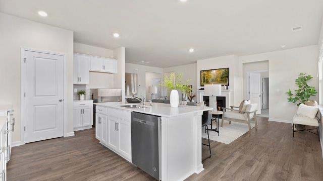 Kitchen and island with quartz countertops, white cabinets, and stainless steel appliances