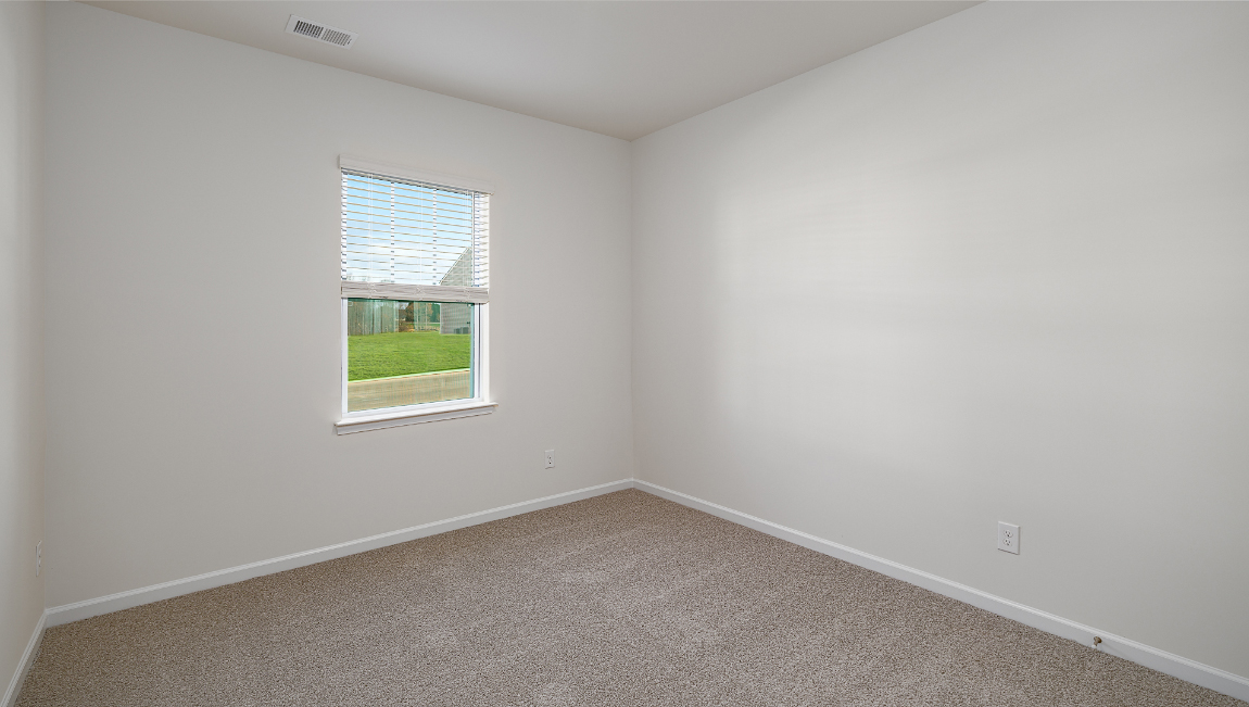 Carpeted bedroom with small window