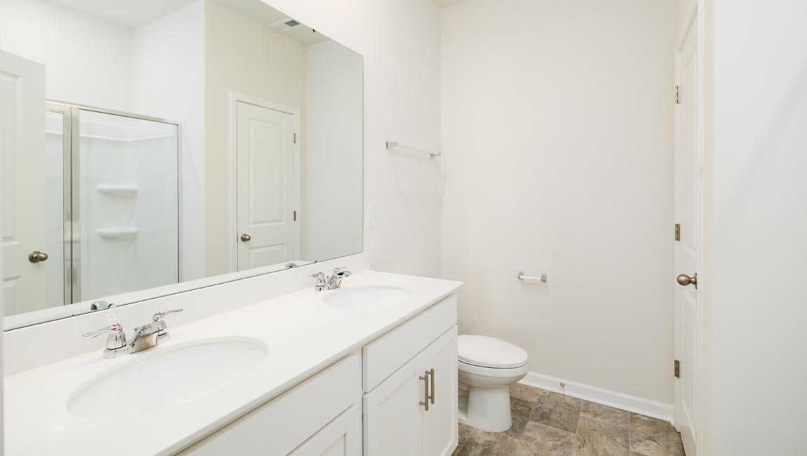 Bathroom with white cabinets and counters, and bathtub