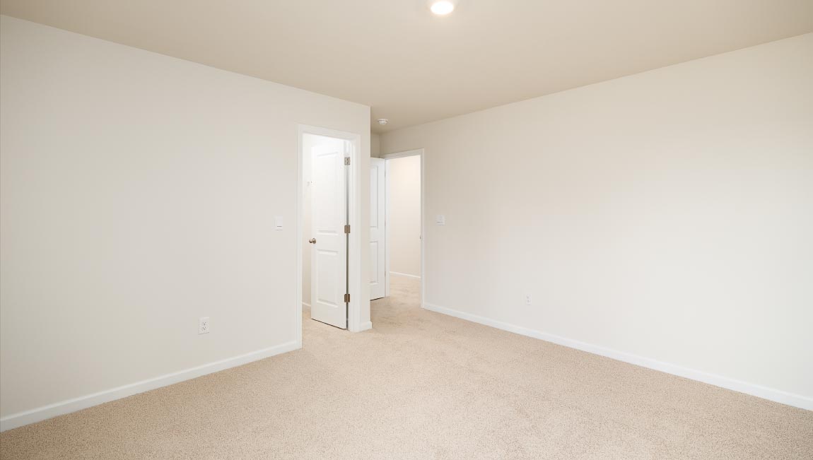 carpeted bedroom with two windows