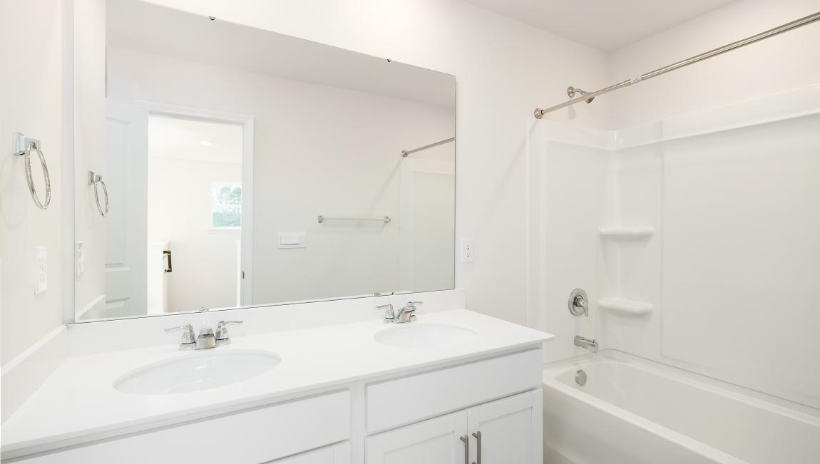 Bathroom with white cabinets and counters, and bathtub