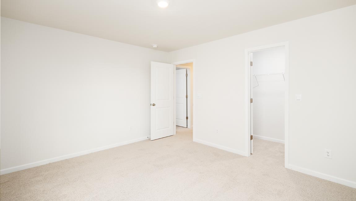 carpeted bedroom with two windows