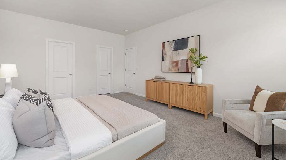 Carpeted primary bedroom with two small windows