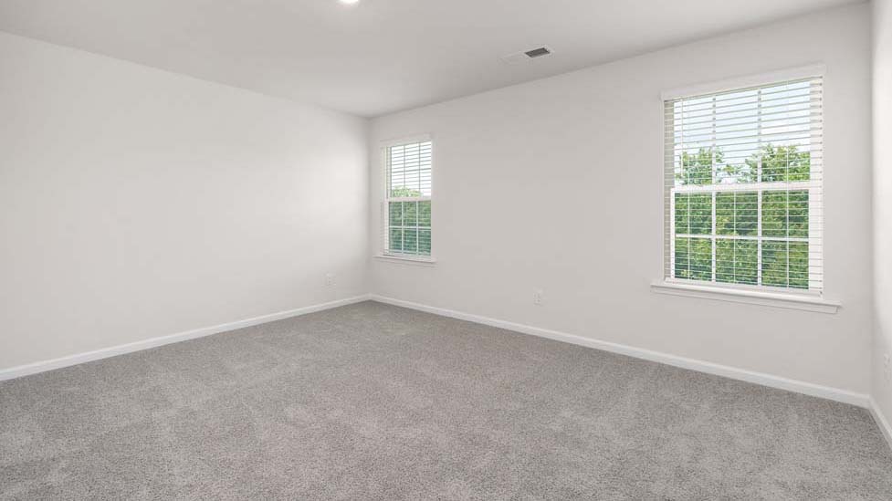 carpeted bedroom with two windows