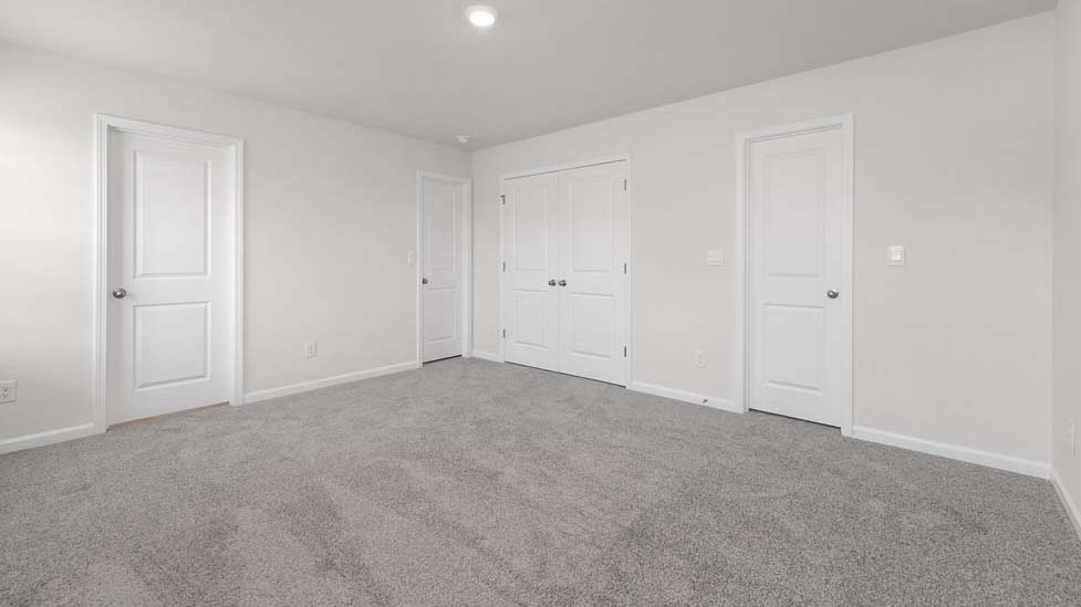 carpeted bedroom with two windows