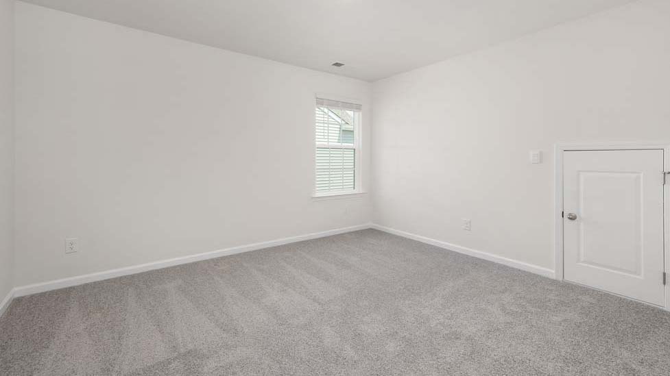carpeted bedroom with two windows