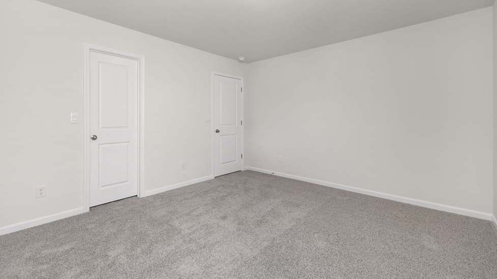 carpeted bedroom with two windows