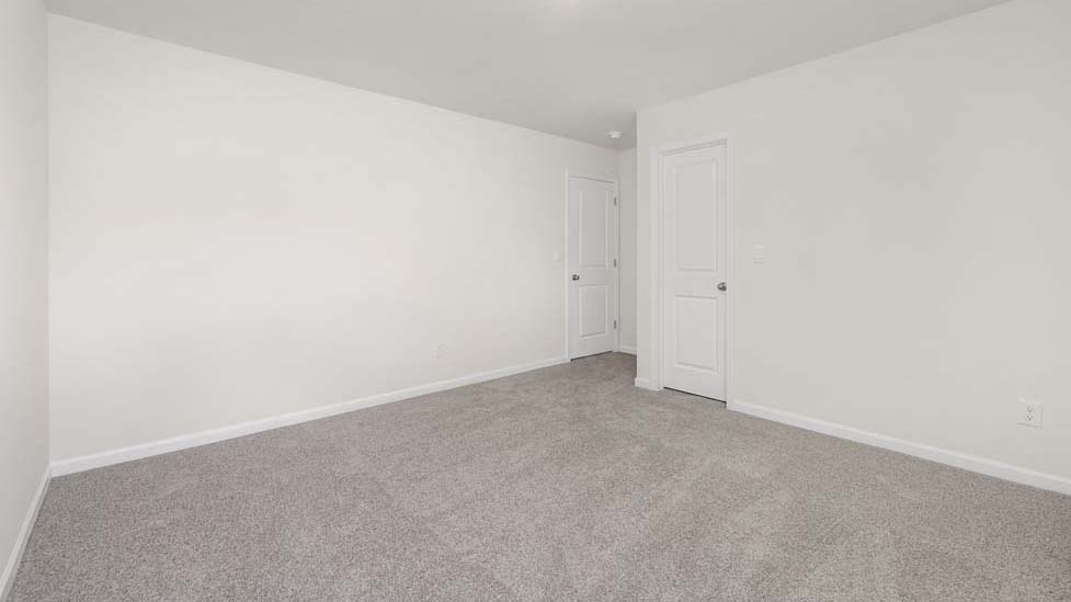 carpeted bedroom with two windows