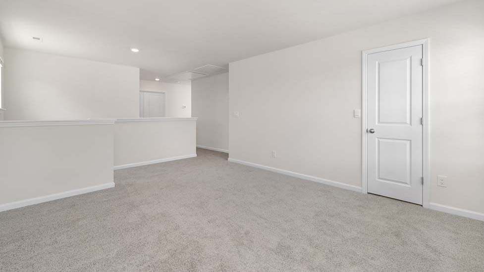 Carpeted loft space atop stairs with large window