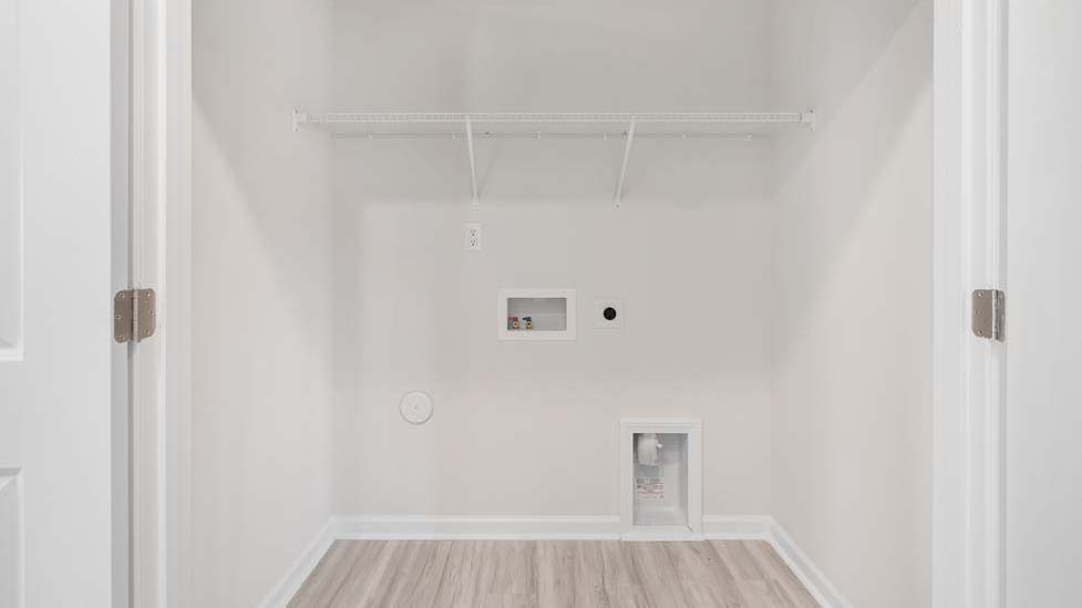 Laundry room with racks above machines