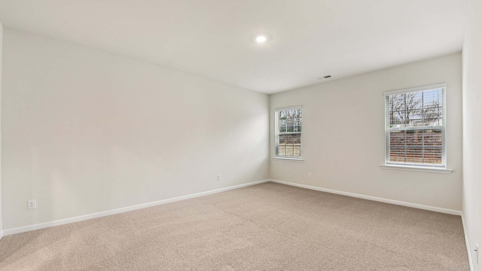 Carpeted bedroom with large windows