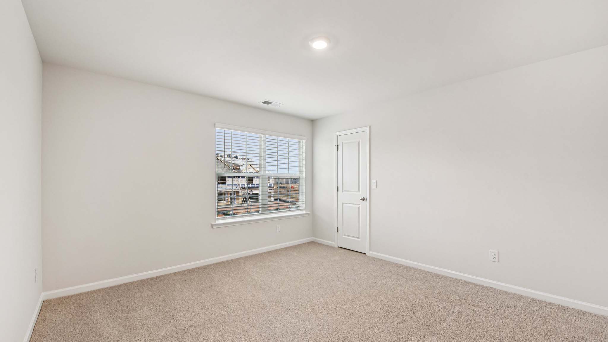 Carpeted bedroom with large windows