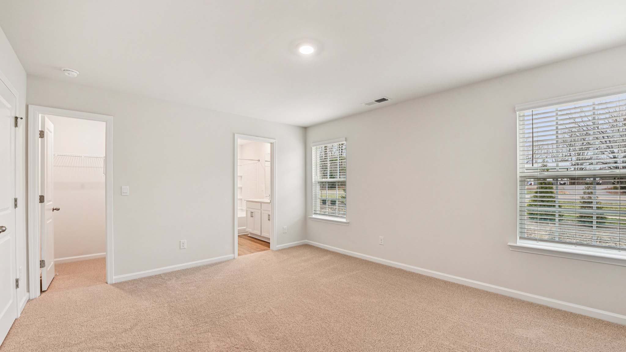 Carpeted bedroom with large windows