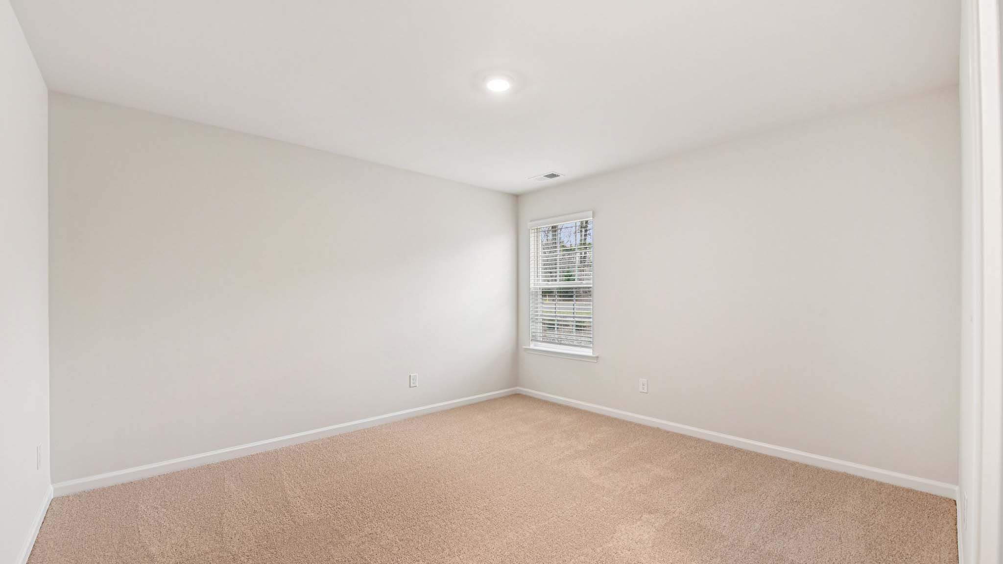 Carpeted bedroom with large windows