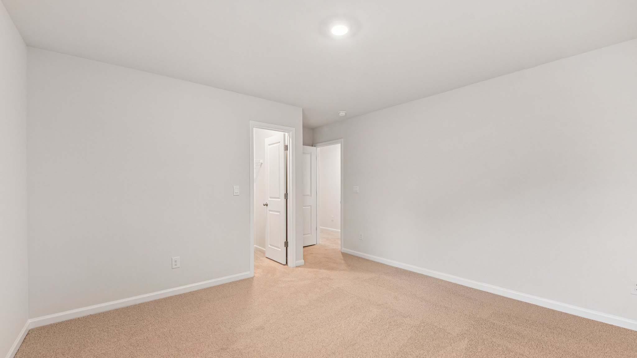 Carpeted bedroom with large windows