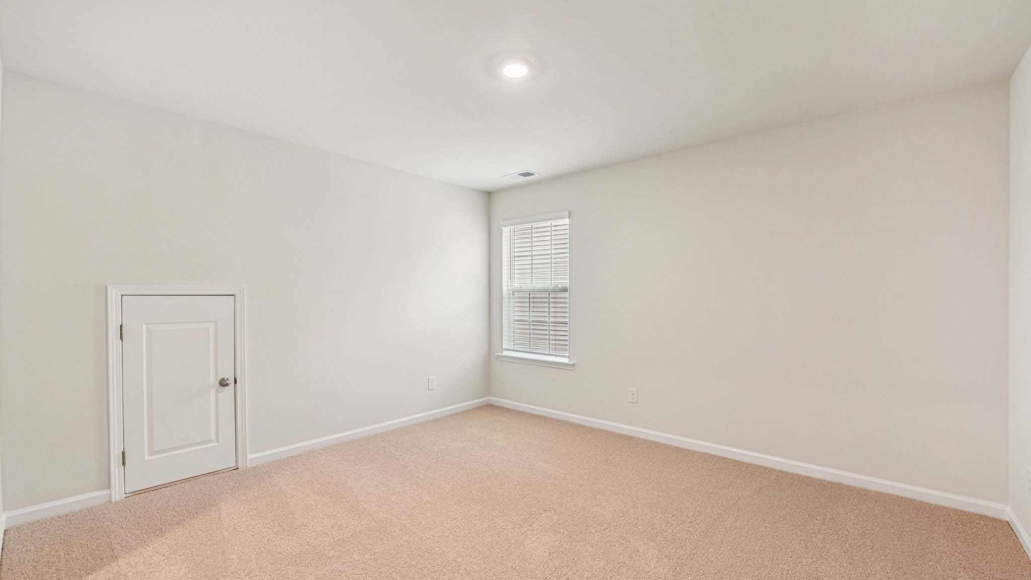 Carpeted bedroom with large windows