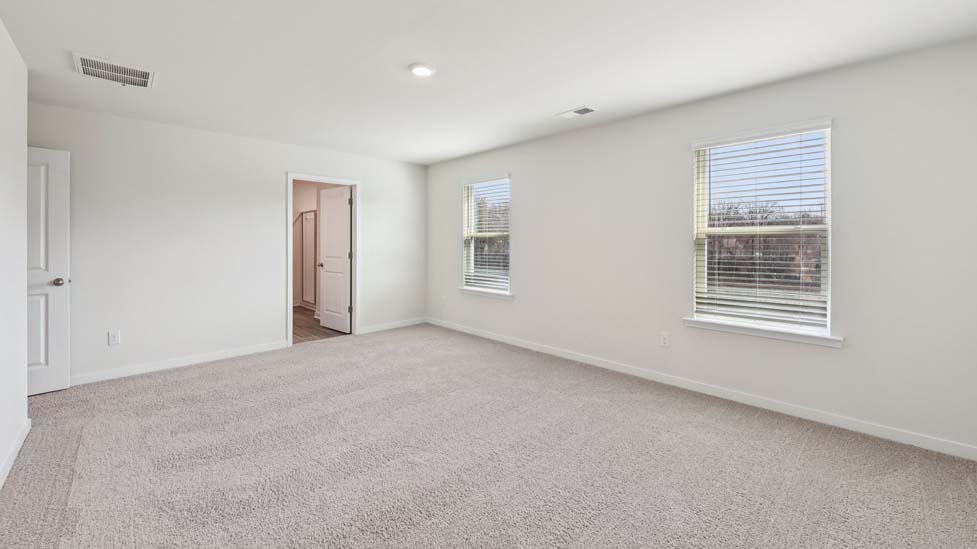 Carpeted bedroom with large windows